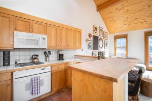 a kitchen with wooden cabinets and a counter top at Sugarloaf by AvantStay Telluride Home In Great Location Near the Slopes in Telluride
