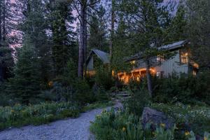 a house in the woods at night with lights at Everett by AvantStay 5mins to Squaw Valley wPool & HOT TUB in Olympic Valley