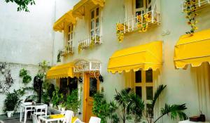 a building with yellow umbrellas and tables and chairs at Stay Banaras - A Boutique Hotel in Varanasi