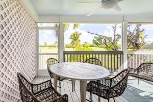 a patio with a table and chairs on a porch at Paradise Point by AvantStay Golf Course Living in Stock Island