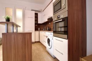 een keuken met witte apparatuur en een wasmachine en droger bij Standard Apartment by Hi5 - Dessewffy 2 bedroom in Boedapest