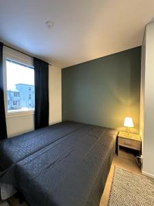 Un dormitorio con una cama grande y una ventana en Kotimaailma Apartments #6 - Hieno ja tilava kaksio keskustassa, en Seinäjoki