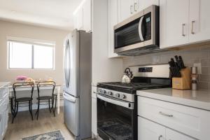 a kitchen with a stove and a microwave at Seashore III by AvantStay In the Heart of La Jolla 5mins from the Beach in San Diego