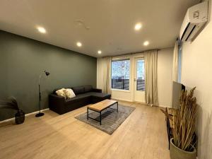 sala de estar con sofá y mesa en Kotimaailma Apartments #6 - Hieno ja tilava kaksio keskustassa en Seinäjoki