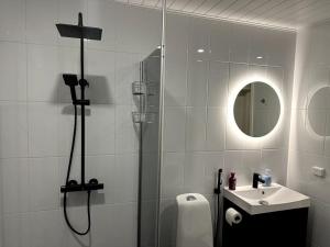 La salle de bains est pourvue d'une douche et d'un lavabo. dans l'établissement Kotimaailma Apartments #6 - Hieno ja tilava kaksio keskustassa, à Seinäjoki