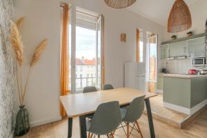 eine Küche und ein Esszimmer mit einem Tisch und Stühlen in der Unterkunft Duplex spacieux et design proche la Part-Dieu in Lyon