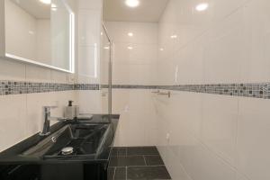 ein Bad mit einem Waschbecken und einem Spiegel in der Unterkunft Duplex spacieux et design proche la Part-Dieu in Lyon