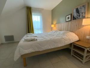 a bedroom with a large bed and a window at Maison 6 personnes avec terrasse, piscines et sauna in Pornichet +15 photos