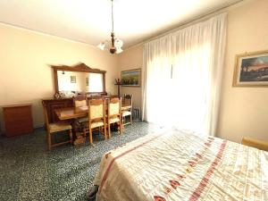 1 dormitorio con cama, mesa y comedor en La Casa Di Ida, en Baiano