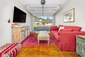 a living room with a red couch and a tv at Cherry Blossom by AvantStay 6 Min to Downtown in Asheville