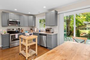 a kitchen with gray cabinets and a wooden table at Cherry Blossom by AvantStay 6 Min to Downtown in Asheville