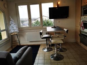 a living room with a couch and a barber chair at L'appart d'Angélique in Imling