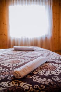 a bed with two towels on it with a window at Світанок у горах in Verkhniy Yasenov