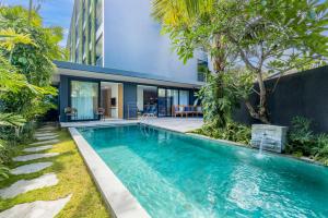 a swimming pool in front of a house at Citadines Berawa Beach Bali in Canggu