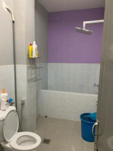 a bathroom with a toilet and a bath tub at Homestay Teratak Saazlina in Seremban