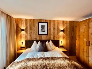 - une chambre avec un lit et des murs lambrissés dans l'établissement Sonn-Alm Chalet-Apartments, à Bichlbach