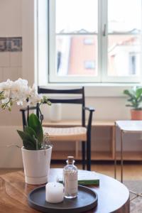 une table avec une bougie et un vase avec des fleurs dans l'établissement FLH Downtown Central Arammish Apartment, à Lisbonne