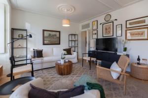 ein Wohnzimmer mit einem Sofa und einem TV in der Unterkunft FLH Downtown Central Arammish Apartment in Lissabon