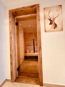 une porte dans un couloir avec une tête de cerf sur le mur dans l'établissement Sonn-Alm Chalet-Apartments, à Bichlbach