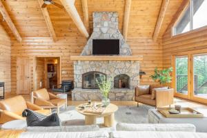a living room with a stone fireplace in a log house at Chester by AvantStay Amazing Views Secluded Home A True City Escape 