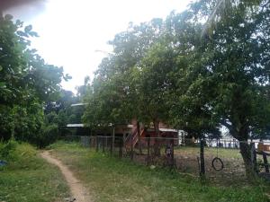 una valla frente a una casa con árboles en River Garden, 