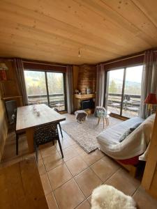 a living room with a couch and a table in a cabin at Apartment with balcony and panoramic view between sky and mountains in Megève