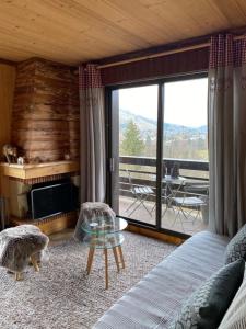a living room with a bed and a glass table at Apartment with balcony and panoramic view between sky and mountains in Megève