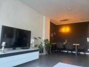 sala de estar con TV grande y mesa de comedor en Luxuriöse Loft Wohnung in Paderborn en Paderborn