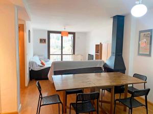 a living room with a table and a room with a bed at Apartamentos Sallent de Gállego 3000 in Sallent de Gállego