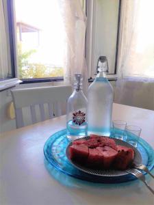un plato de pastel en una mesa con una botella en Summer aura - seaside place, en Istron
