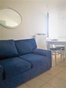 Sofá azul en la sala de estar con espejo en Summer aura - seaside place, en Istron