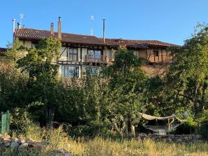 a house on the side of a hill with trees at Casa rural Villapajar in Villasur de Herreros