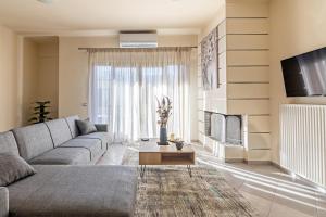 een woonkamer met een bank en een tv bij Zephyrus Cityscape Condo,By IdealStay Experience in Heraklion