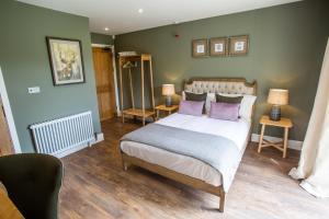 a bedroom with a bed with purple pillows at The Grange in Upper Arley