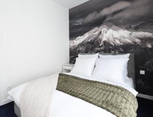 a bedroom with a bed with a picture of a mountain at MagicSki Wisła in Wisła