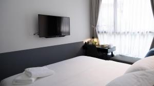 1 dormitorio con 1 cama y TV en la pared en VicHaus Serviced Apartment, en Singapur