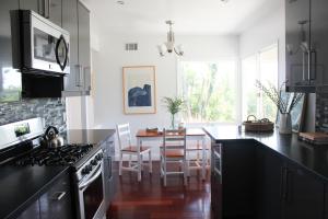 a kitchen with black counter tops and a dining room at Bluff by AvantStay Gorgeous Malibu Getaway w Hot Tub Spectacular Ocean Views in Malibu