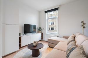 sala de estar con sofá y TV en Verblijf in luxe in Gent design app in centrum 4p en Ghent