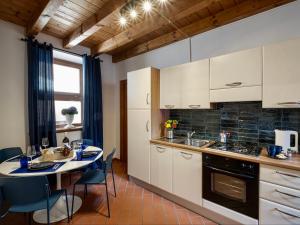 una cocina con armarios blancos y una mesa con sillas. en Xenia19 in pieno centro storico en Peschiera del Garda