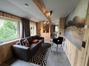 a living room with a black couch and a window at Haus Bergquell App 7 in Willingen