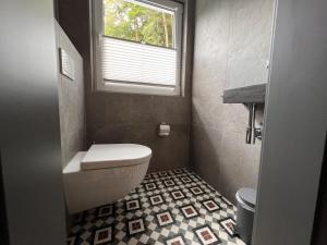 a bathroom with a toilet and a window at Haus Bergquell App 7 in Willingen