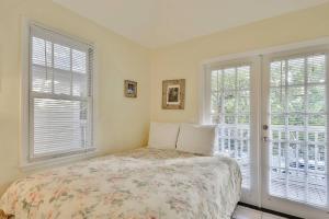 a bedroom with a bed and two windows at A Little Slice Of Paradise by AvantStay Communal Pool Screened in Porch Great Location Month Long Stays in Stock Island