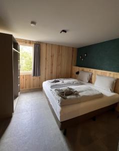 een slaapkamer met twee bedden en een groene muur bij Haus Bergquell App 4 in Willingen