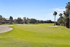 a golf course with palm trees and a green at A Little Slice Of Paradise by AvantStay Communal Pool Screened in Porch Great Location Month Long Stays in Stock Island