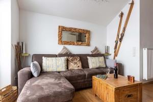 ein Wohnzimmer mit einem braunen Sofa und einem Tisch in der Unterkunft Ferienwohnung Ettelsberg in Willingen in Willingen
