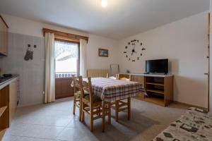Una cocina y un comedor con mesa y sillas. en Black Lake Studios - Trepalle, en Livigno