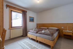un dormitorio con una cama y una ventana en Black Lake Studios - Trepalle, en Livigno