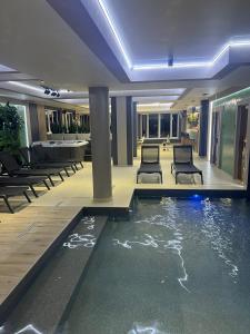 a hotel lobby with a swimming pool and chairs at Guest House Zatyshnyi Dvir in Bukovel