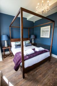 1 dormitorio con cama con dosel y paredes azules en The Grange en Upper Arley