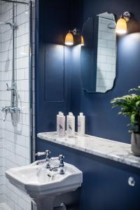 a blue bathroom with a sink and a mirror at The Grange in Upper Arley